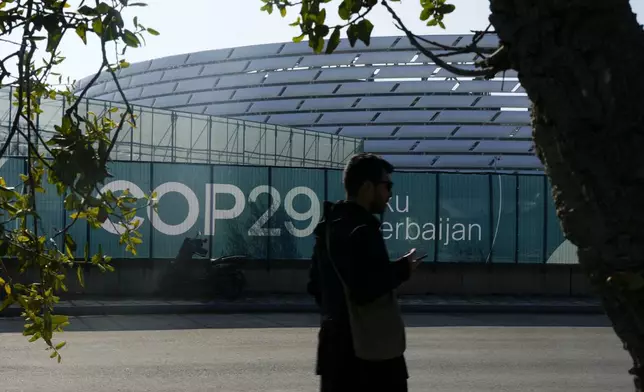 A person walks outside the Baku Olympic Stadium, the venue for the COP29 U.N. Climate Summit, Sunday, Nov. 10, 2024, in Baku, Azerbaijan. (AP Photo/Rafiq Maqbool)