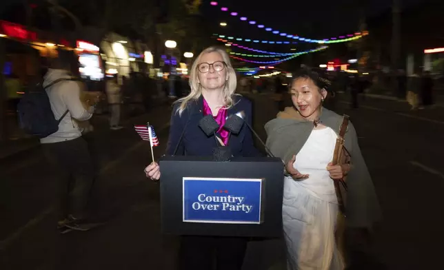 Dressed as Liz Cheney, Maggie Langrick, left, walks with Lulu Hansen during the Halloween Carnival in West Hollywood, Calif., Thursday, Oct. 31, 2024. (AP Photo/Jae C. Hong)