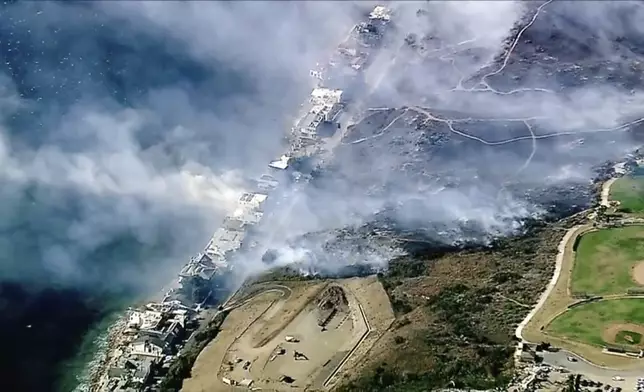 In this aerial still image provided by KABC-TV, shows Los Angeles County Fire Department crews scrambled to contain a small blaze fed by erratic wind gusts that pushed flames through dry brush near Broad Beach along Pacific Coast Highway in Malibu on Wednesday, Nov. 6, 2024. (KABC-TV via AP)