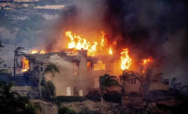 Flames consume a home as the Mountain Fire burns in Camarillo, Calif., on Wednesday, Nov. 6, 2024. (AP Photo/Noah Berger)