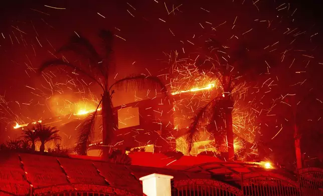 Flames consume a home as the Mountain Fire burns in Camarillo, Calif., on Wednesday, Nov. 6, 2024. (AP Photo/Noah Berger)