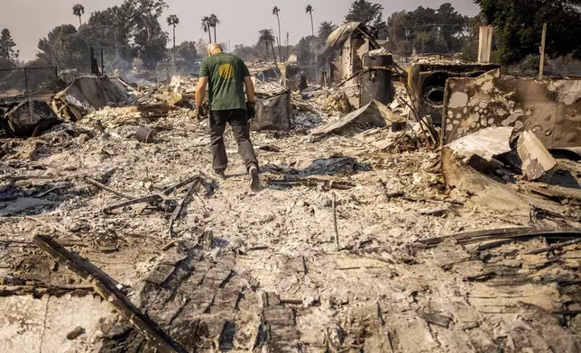 Marvin Meador walks on the remains of his fire-ravaged property after the Mountain Fire swept through, Thursday, Nov. 7, 2024, in Camarillo, Calif. (AP Photo/Ethan Swope)