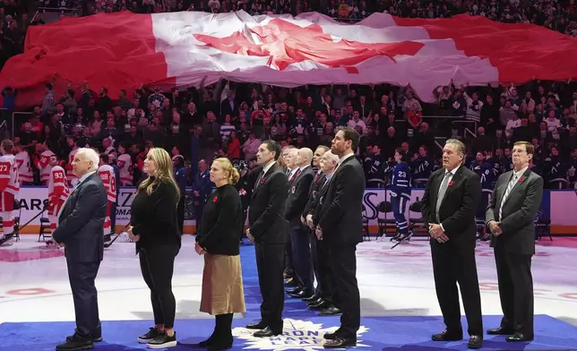 2024 Hockey Hall of Fame inductees Colin Campbell, left to right, Krissy Wendell-Pohl, Natalie Darwitz, Pavel Datsyuk, Shea Weber, Jeremy Roenick and David Poile stand for the national anthems following a pre-game ceremony prior to NHL hockey action between the Detroit Red Wings and Toronto Maple Leafs in Toronto on Friday, November 8, 2024. (Frank Gunn/The Canadian Press via AP)