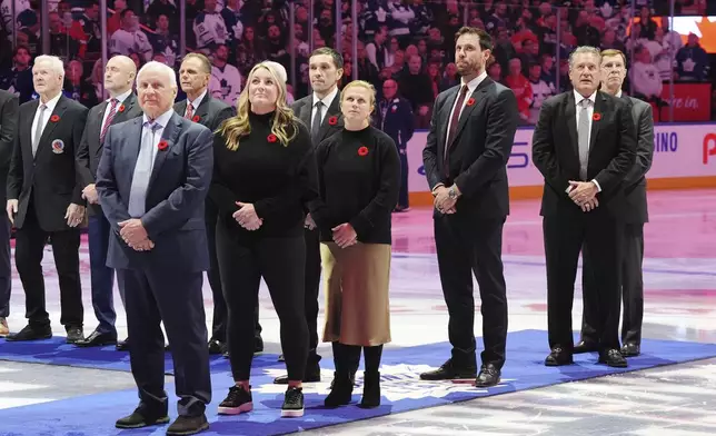 2024 Hockey Hall of Fame inductees Colin Campbell, left to right, Krissy Wendell-Pohl, Pavel Datsyuk, Natalie Darwitz, Shea Weber, Jeremy Roenick and David Poile stand for the national anthems following a pre-game ceremony prior to NHL hockey action between the Detroit Red Wings and Toronto Maple Leafs in Toronto on Friday, November 8, 2024. (Frank Gunn/The Canadian Press via AP)