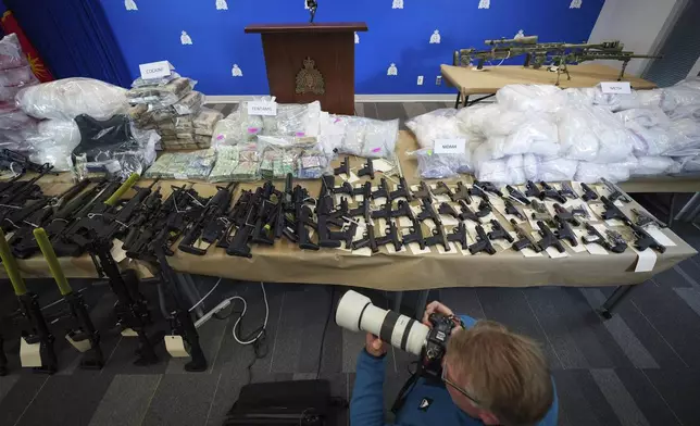 Firearms and illicit drugs seized last week are displayed before a news conference at Royal Canadian Mounted Police (RCMP) headquarters, in Surrey, British Columbia, Thursday, Oct. 31, 2024. (Darryl Dyck/The Canadian Press via AP)