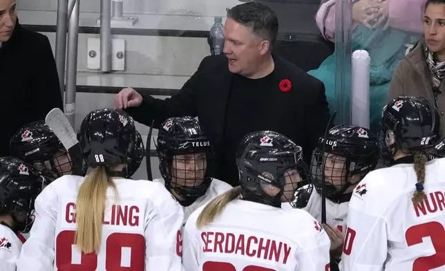 Canada head coach Troy Ryan talks with his player during a timeout against United States in the first period of a women's Rivalry Series hockey game in San Jose, Calif., Wednesday, Nov. 6, 2024. (AP Photo/Tony Avelar)