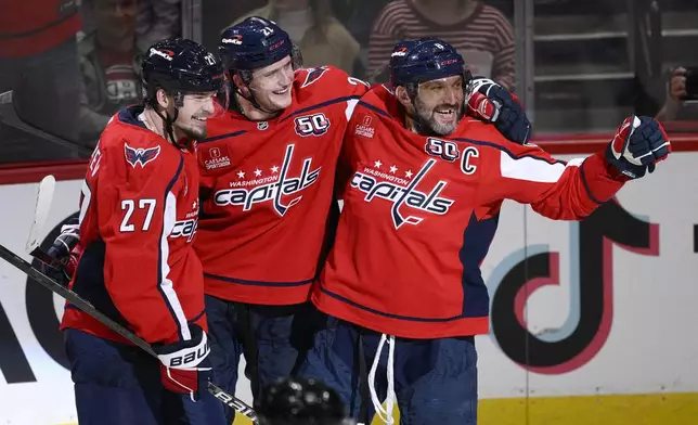 Washington Capitals left wing Alex Ovechkin, right, celebrates his goal with center Aliaksei Protas (21) and defenseman Alexander Alexeyev (27) during the third period of an NHL hockey game against the Montreal Canadiens, Thursday, Oct. 31, 2024, in Washington. The Capitals won 6-3. (AP Photo/Nick Wass)