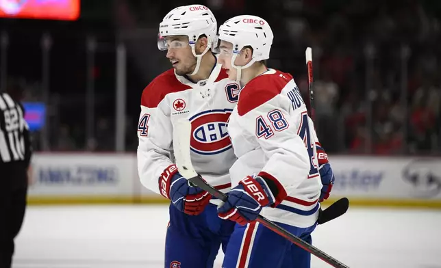 Montreal Canadiens center Nick Suzuki, left, celebrates his goal with defenseman Lane Hutson (48) during the second period of an NHL hockey game against the Washington Capitals, Thursday, Oct. 31, 2024, in Washington. (AP Photo/Nick Wass)