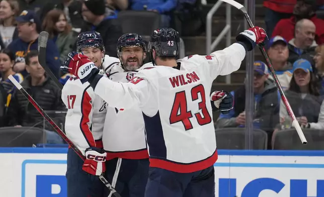 Washington Capitals' Alex Ovechkin, center, is congratulated by teammates Dylan Strome and Tom Wilson (43) after scoring during the third period of an NHL hockey game against the St. Louis Blues Saturday, Nov. 9, 2024, in St. Louis. (AP Photo/Jeff Roberson)