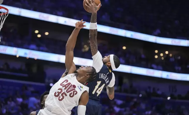 New Orleans Pelicans forward Brandon Ingram (14) leaps for a rebound over Cleveland Cavaliers forward Isaac Okoro (35) in the first half of an NBA basketball game in New Orleans, Wednesday, Nov. 6, 2024. (AP Photo/Gerald Herbert)