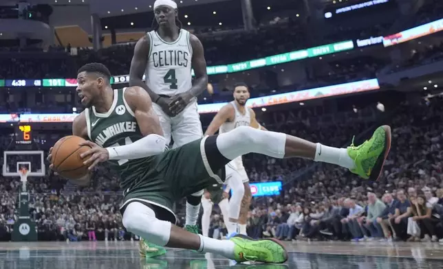 Milwaukee Bucks' Giannis Antetokounmpo falls in front of Boston Celtics' Jrue Holiday during the second half of an NBA basketball game Sunday, Nov. 10, 2024, in Milwaukee. (AP Photo/Morry Gash)