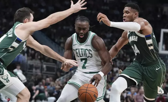 Boston Celtics' Jaylen Brown drives between Milwaukee Bucks' Pat Connaughton and Giannis Antetokounmpo during the first half of an NBA basketball game Sunday, Nov. 10, 2024, in Milwaukee. (AP Photo/Morry Gash)