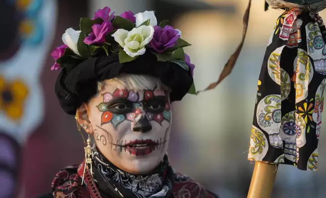 Marnee Ostoa Garciam 29, walks in a Day of the Dead procession, Friday, Nov. 1, 2024, in the Pilsen neighborhood of Chicago. (AP Photo/Erin Hooley)