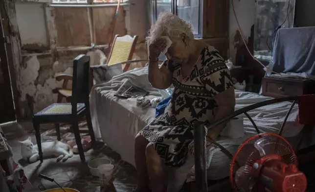 FILE - Margarita Salazar wipes sweat off her brow inside her home amid high heat in Veracruz, Mexico, June 16, 2024. (AP Photo/Felix Marquez, File)