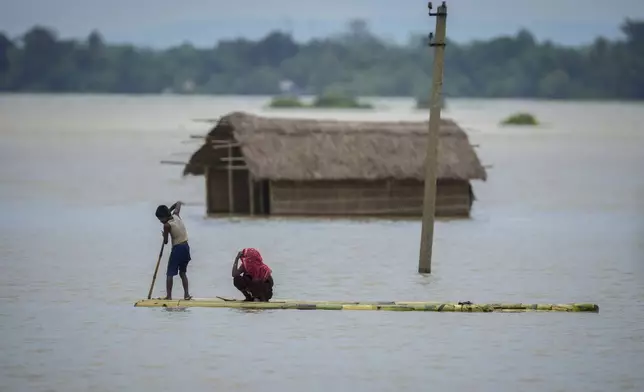 FILE - A young boy rows a makeshift banana raft to cross floodwaters in Morigaon district in the northeastern Indian state of Assam, India, July 3, 2024. (AP Photo/Anupam Nath, File)