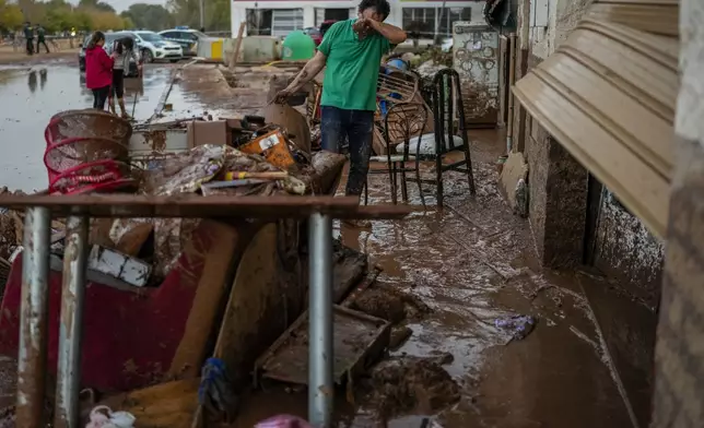 FILE - A man cleans his house affected by floods in Utiel, Spain, Oct. 30, 2024. (AP Photo/Manu Fernandez, File)