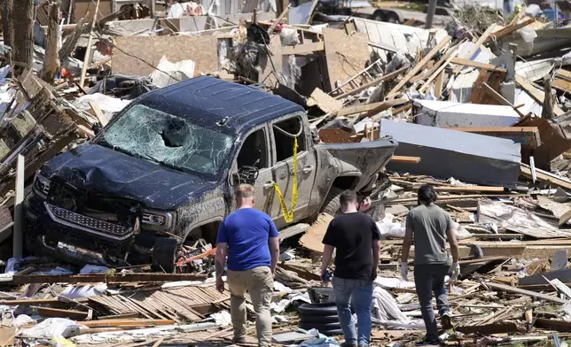 FILE - Local residents walk among the debris from tornado damaged homes, May 22, 2024, in Greenfield, Iowa. (AP Photo/Charlie Neibergall, File)