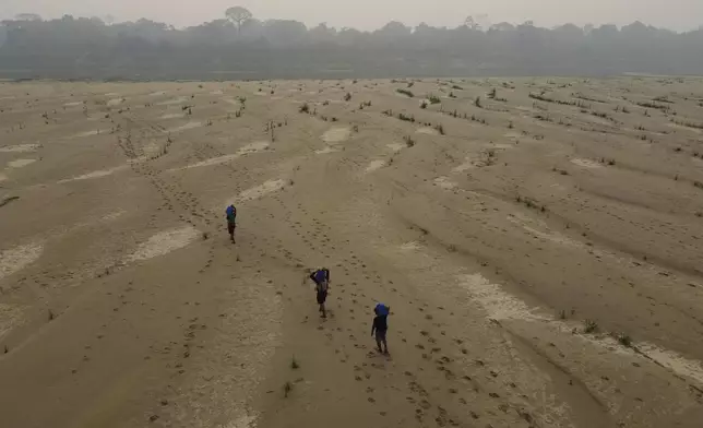 FILE - Residents transport drinking water from Humaita to the Paraizinho community, along the dry Madeira River, a tributary of the Amazon River, amid a drought, in Amazonas state, Brazil, Sunday, Sept. 8, 2024. (AP Photo/Edmar Barros)