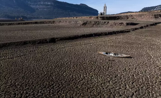 FILE - An abandoned canoe sits on the cracked ground at the Sau reservoir in Vilanova de Sau, north of Barcelona, Spain, Jan. 26, 2024. (AP Photo/Emilio Morenatti, File)