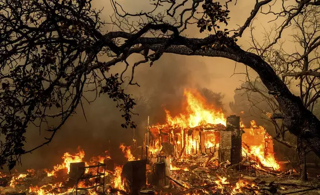 FILE - Flames consume a structure on Bessie Lane as the Thompson Fire burns in Oroville, Calif., July 2, 2024. (AP Photo/Noah Berger, File)