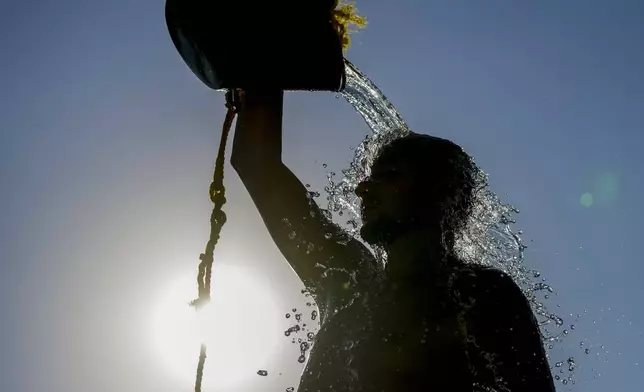 FILE - A man rinses with fresh water after playing beach volleyball on a hot day, at the Ramlet al-Baida public beach in Beirut, Lebanon, July 16, 2024. (AP Photo/Hassan Ammar, File)