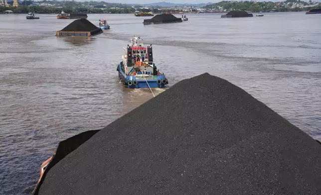 FILE - Tug boats pull barges fully loaded with coal on the Mahakam River in Samarinda, East Kalimantan, Indonesia, on Dec. 19, 2022. (AP Photo/Dita Alangkara, File)