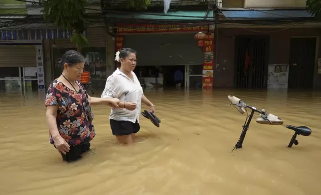 FILE - People wade in a flooded street in the aftermath of Typhoon Yagi, in Hanoi, Vietnam, on Sept. 12, 2024. (AP Photo/Hau Dinh, File)