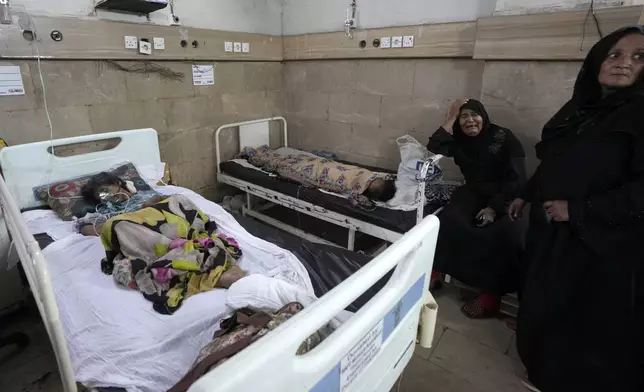 FILE - A woman, center, weeps as patients of heatstroke receive treatment at a hospital in Karachi, Pakistan, June 25, 2024. (AP Photo/Fareed Khan, File)