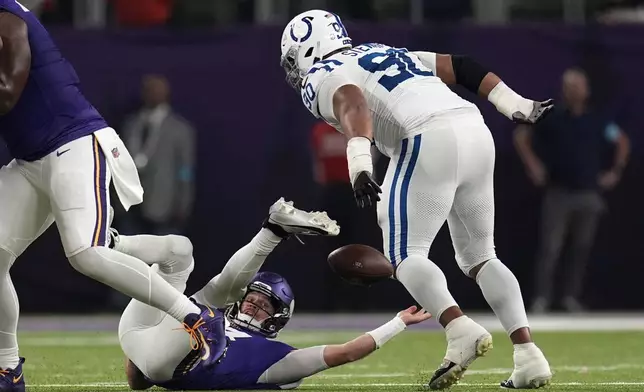 Minnesota Vikings quarterback Sam Darnold fumbles as he is tackled by Indianapolis Colts defensive tackle Grover Stewart, right, during the first half of an NFL football game, Sunday, Nov. 3, 2024, in Minneapolis. (AP Photo/Abbie Parr)