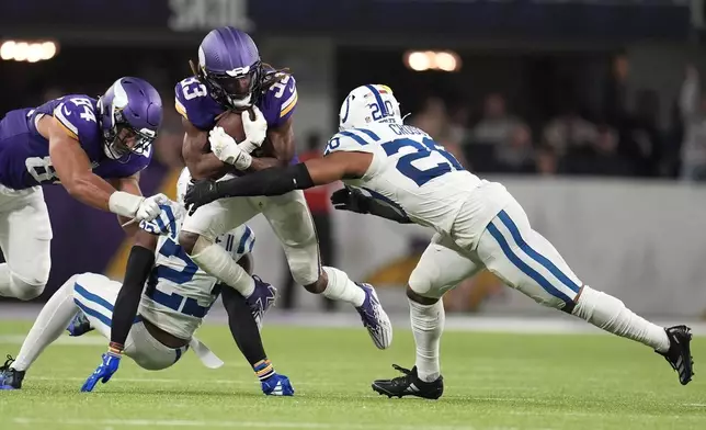 Minnesota Vikings running back Aaron Jones (33) is tackled by Indianapolis Colts safety Nick Cross (20) during the second half of an NFL football game, Sunday, Nov. 3, 2024, in Minneapolis. (AP Photo/Abbie Parr)