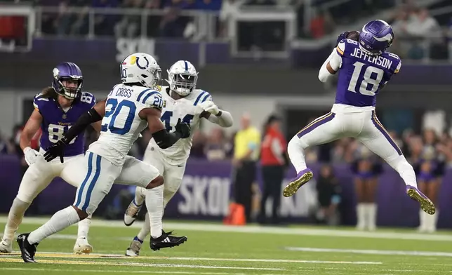 Minnesota Vikings wide receiver Justin Jefferson (18) catches a pass in front of Indianapolis Colts safety Nick Cross (20) during the first half of an NFL football game, Sunday, Nov. 3, 2024, in Minneapolis. (AP Photo/Abbie Parr)