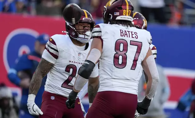 Washington Commanders running back Chris Rodriguez Jr. (23) celebrates with tight end John Bates (87) after gaining a first down against the New York Giants during the fourth quarter of an NFL football game, Sunday, Nov. 3, 2024, in East Rutherford, N.J. (AP Photo/Seth Wenig)