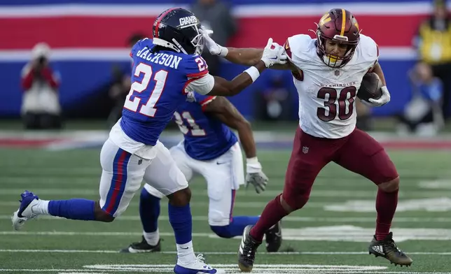 Washington Commanders running back Austin Ekeler (30) carries the ball against New York Giants cornerback Adoree' Jackson (21) during the fourth quarter of an NFL football game, Sunday, Nov. 3, 2024, in East Rutherford, N.J. (AP Photo/Seth Wenig)