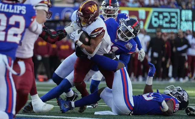 Washington Commanders running back Austin Ekeler (30) pushes past New York Giants linebacker Azeez Ojulari (51) to score a touchdown during the second quarter of an NFL football game, Sunday, Nov. 3, 2024, in East Rutherford, N.J. (AP Photo/Seth Wenig)