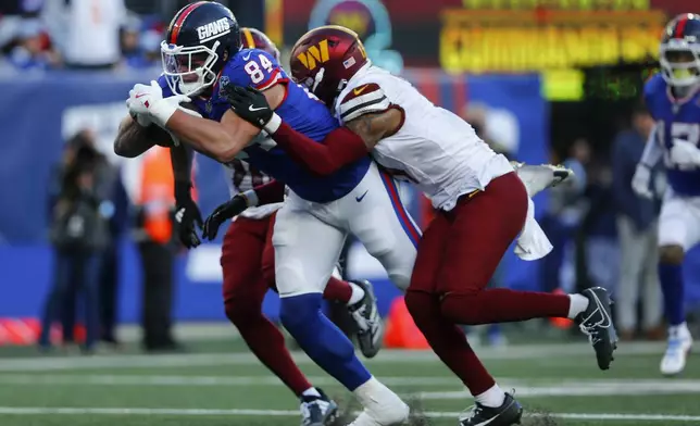 New York Giants tight end Theo Johnson (84) pushes through the Washington Commanders defense on his way to a touchdown during the fourth quarter of an NFL football game, Sunday, Nov. 3, 2024, in East Rutherford, N.J. (AP Photo/John Munson)