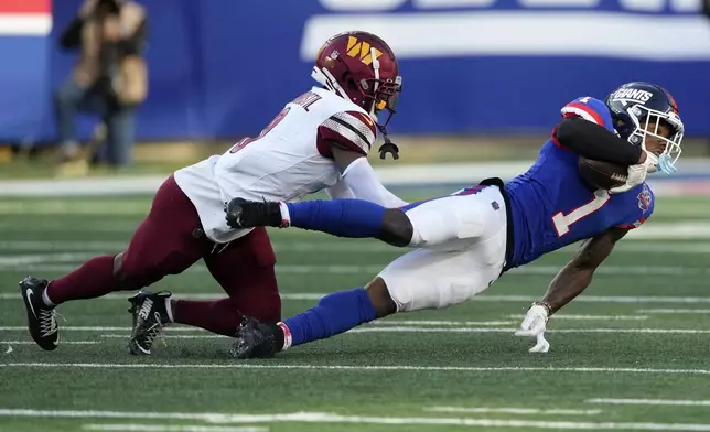 New York Giants wide receiver Malik Nabers (1) comes down with a pass against Washington Commanders cornerback Mike Sainristil (0) during the fourth quarter of an NFL football game, Sunday, Nov. 3, 2024, in East Rutherford, N.J. (AP Photo/Seth Wenig)