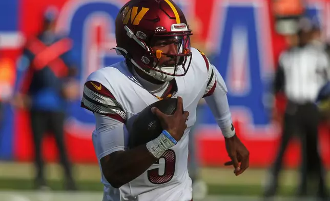 Washington Commanders quarterback Jayden Daniels (5) carries the ball against the New York Giants during the second quarter of an NFL football game, Sunday, Nov. 3, 2024, in East Rutherford, N.J. (AP Photo/John Munson)