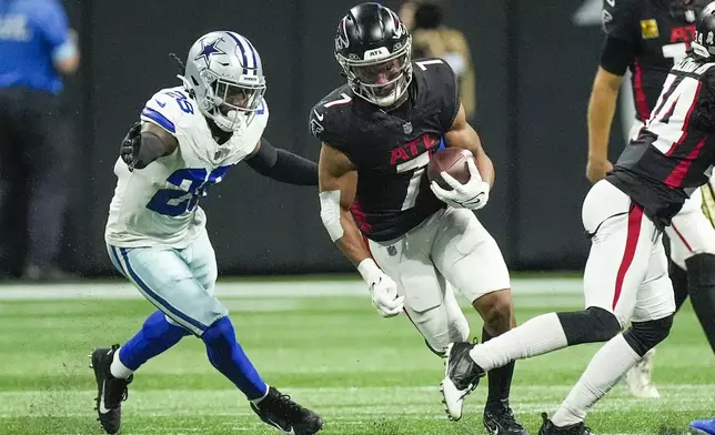 Atlanta Falcons running back Bijan Robinson (7) carries past Dallas Cowboys safety Malik Hooker (28) during the second half of an NFL football game, Sunday, Nov. 3, 2024, in Atlanta. (AP Photo/ John Bazemore)