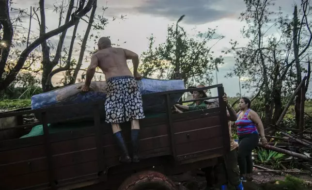 People load a mattress into a truck after their home was destroyed by Hurricane Rafael, in Alquizar, Cuba, Thursday, Nov. 7, 2024. (AP Photo/Ramon Espinosa)