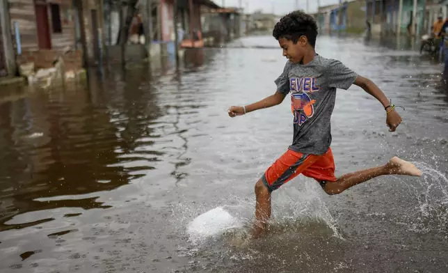 A youth plays in a flooded street after the passing of Hurricane Rafael in Batabano, Cuba, Thursday, Nov. 7, 2024. (AP Photo/Ramon Espinosa)