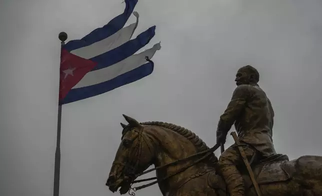 A Cuban flag shredded by the winds of Hurricane Rafael flies above the statue of General Calixto Garcia in Havana, Cuba, Wednesday, Nov. 6, 2024. (AP Photo/Ramon Espinosa)