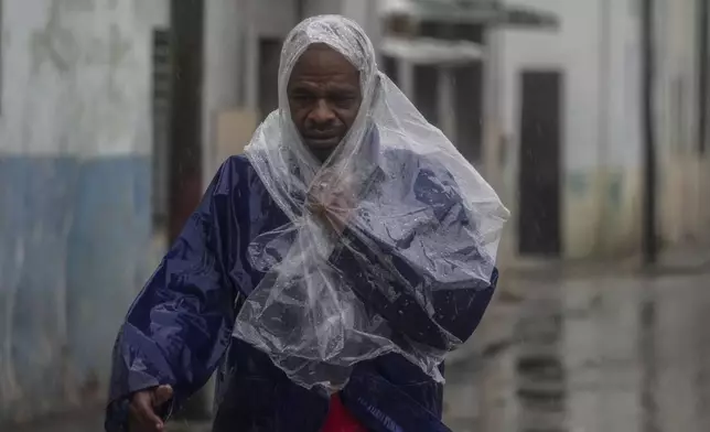 A man walks through the wind and rain brought by Hurricane Rafael in Havana, Cuba, Wednesday, Nov. 6, 2024. (AP Photo/Ramon Espinosa)