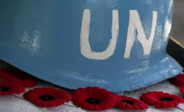 An old U.N helmet is seen with the red poppies is seen during a commemoration for the 60th anniversary of Canada's contribution to the UN Peacekeeping Force in Cyprus at Wolseley Barracks inside a UN-controlled buffer zone cleaving the capital Nicosia, Cyprus, on Monday, Nov. 11, 2024. (AP Photo/Petros Karadjias)