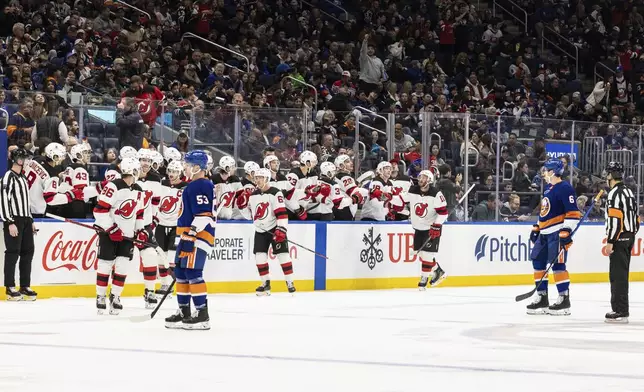 New Jersey Devils right wing Stefan Noesen (11) fist-bumps teammates after scoring during the second period in an NHL hockey game against the New York Islanders, Saturday, Nov. 9, 2024, in Elmont, N.Y. (AP Photo/Stefan Jeremiah)