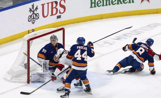 New York Islanders goaltender Ilya Sorokin (30) watches the puck fly over the goal during the first period in an NHL hockey game against the New Jersey Devils Saturday, Nov. 9, 2024, in Elmont, N.Y. (AP Photo/Stefan Jeremiah)