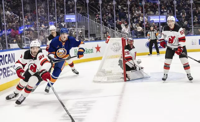 New Jersey Devils defenseman Brett Pesce (22) stretches for the puck during the second period in an NHL hockey against the New York Islanders, Saturday, Nov. 9, 2024, in Elmont, N.Y. (AP Photo/Stefan Jeremiah)