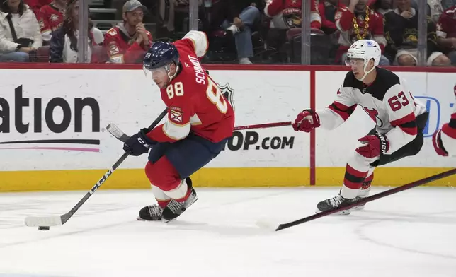 Florida Panthers defenseman Nate Schmidt (88) skates with the puck as New Jersey Devils left wing Jesper Bratt (63) defends during the first period of an NHL hockey game, Tuesday, Nov. 12, 2024, in Sunrise, Fla. (AP Photo/Lynne Sladky)