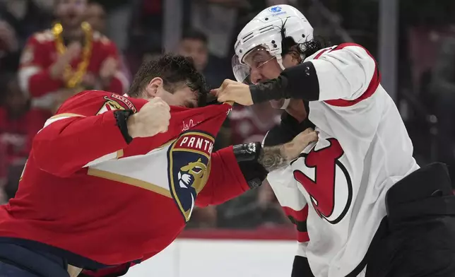 Florida Panthers left wing Jonah Gadjovich, left, and New Jersey Devils defenseman Brenden Dillon, right, trade blows during the second period of an NHL hockey game, Tuesday, Nov. 12, 2024, in Sunrise, Fla. (AP Photo/Lynne Sladky)