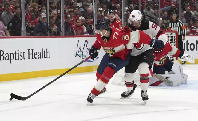 Florida Panthers defenseman Niko Mikkola (77) and New Jersey Devils left wing Erik Haula (56) go for the puck during the first period of an NHL hockey game, Tuesday, Nov. 12, 2024, in Sunrise, Fla. (AP Photo/Lynne Sladky)