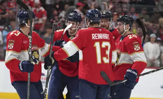 Florida Panthers center Sam Reinhart (13) is congratulated after scoring a goal during the second period of an NHL hockey game against the New Jersey Devils, Tuesday, Nov. 12, 2024, in Sunrise, Fla. (AP Photo/Lynne Sladky)